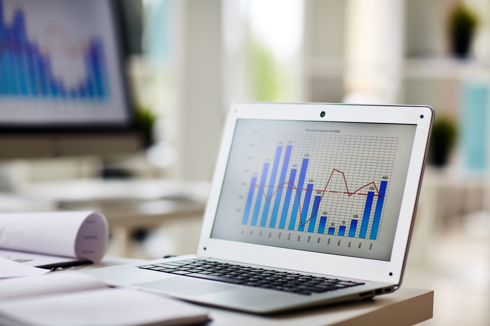 Laptop with chart on its display at workplace of economist